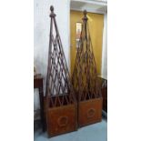 PLANTERS, a pair, oxidised metal with associated obelisks, 284cm x 44.5cm x 44.5cm approx. (2)