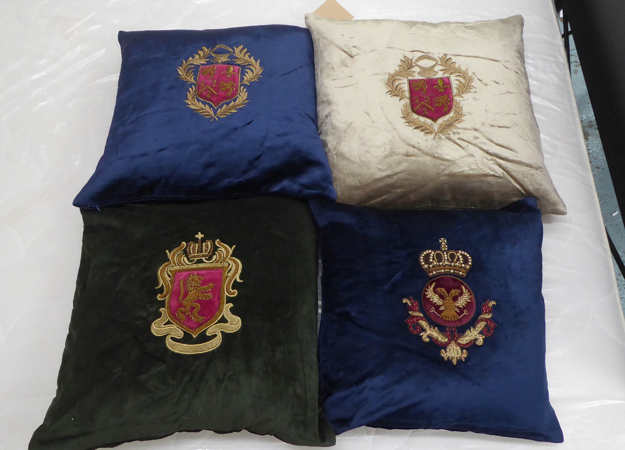 CUSHIONS, a set of four, with embroidered armorial crests, various colours, 44cm x 44cm. (4)