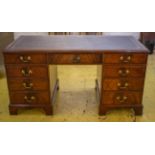 PEDESTAL DESK, Georgian style mahogany with burgundy leather top above seven drawers, 77cm H x 154cm