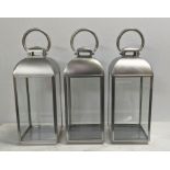 STORM LANTERNS, a set of three, contemporary polished metal, 61cm H. (3)