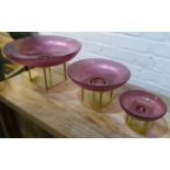 MURANO STYLE GLASS BOWLS ON METAL STANDS, a graduated set of three, largest 19cm H x 35cm D. (3)