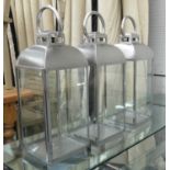 STORM LANTERNS, a set of three, polished metal and glass, 60cm H. (3)