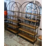 MAISONS DU MONDE ARCH SHAPED SHELVING UNITS, a pair, black metal framed, each enclosing wooden