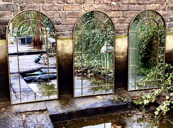 ARCHITECTURAL GARDEN WALL MIRRORS, a set of three, bronzed arch top frames, 107cm x 56cm. (3)