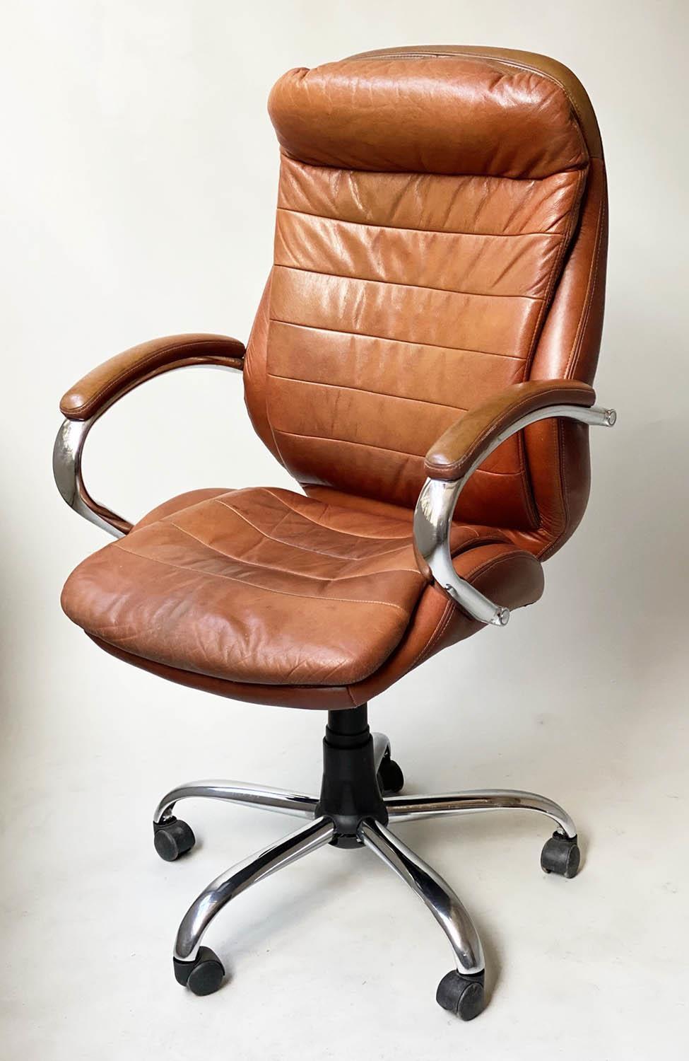 REVOLVING AND RECLINING DESK CHAIR, 1970's, stitched tan leather, on a djustable base, with castors,