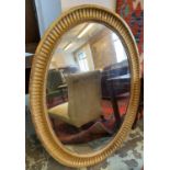 WALL MIRROR, 19th century with an oval gilt frame enclosing an antiqued plate, 107cm H x 81cm.