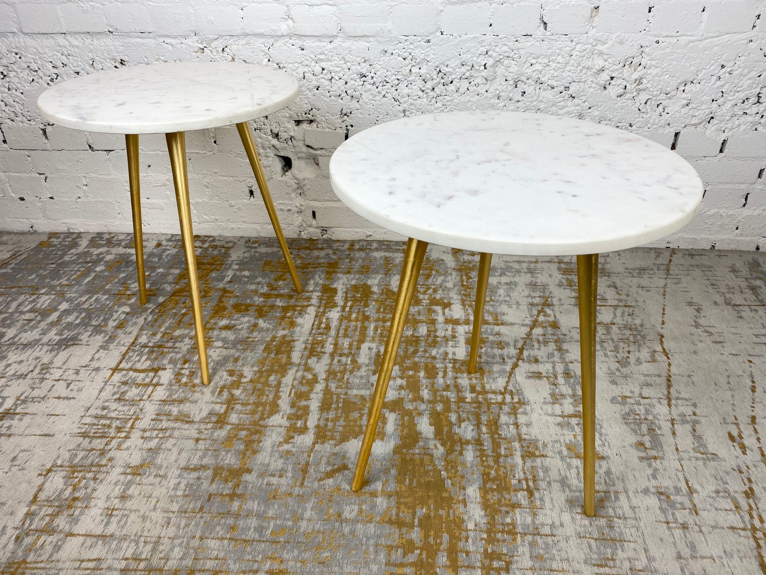 LAMP TABLES, a pair, 1970's Italian design, circular marble tops on tripod gilt metal legs, 54cm H x