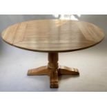 CIRCULAR DINING TABLE, solid oak with fold away flaps forming a smaller square table and turned