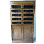 HABERDASHERY CABINET, mid 20th century oak with ten glazed drawers above two panelled doors