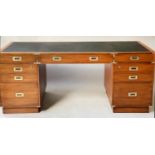 PEDESTAL DESK, Campaign style faded teak and brass bound with nine drawers and tooled black