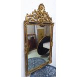 WALL MIRROR, Continental style rectangular gilt with an ornate leaf and scroll decorated surmount,