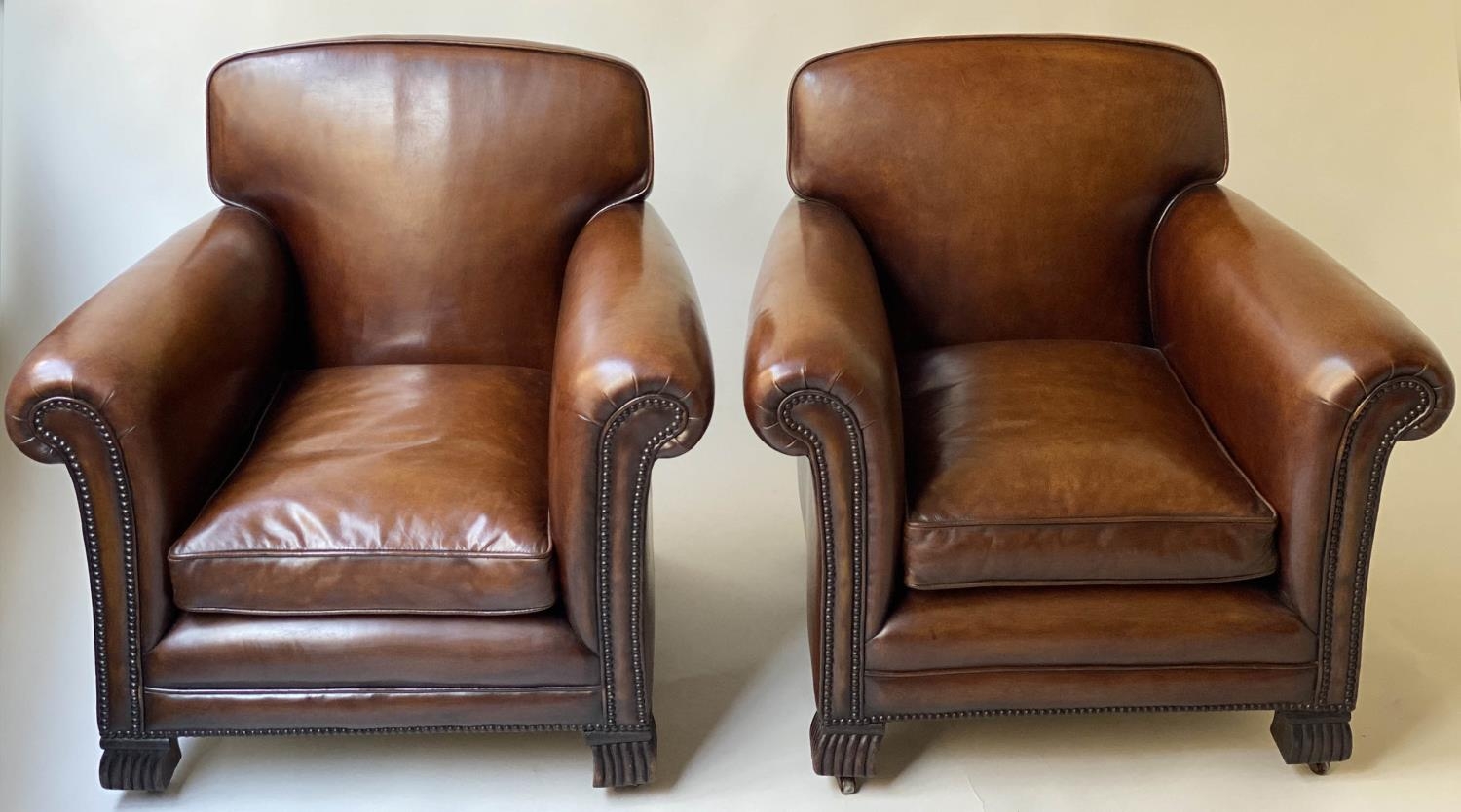 CLUB ARMCHAIRS, a pair, French Art Deco period with hand dyed leaf brown piped and studded