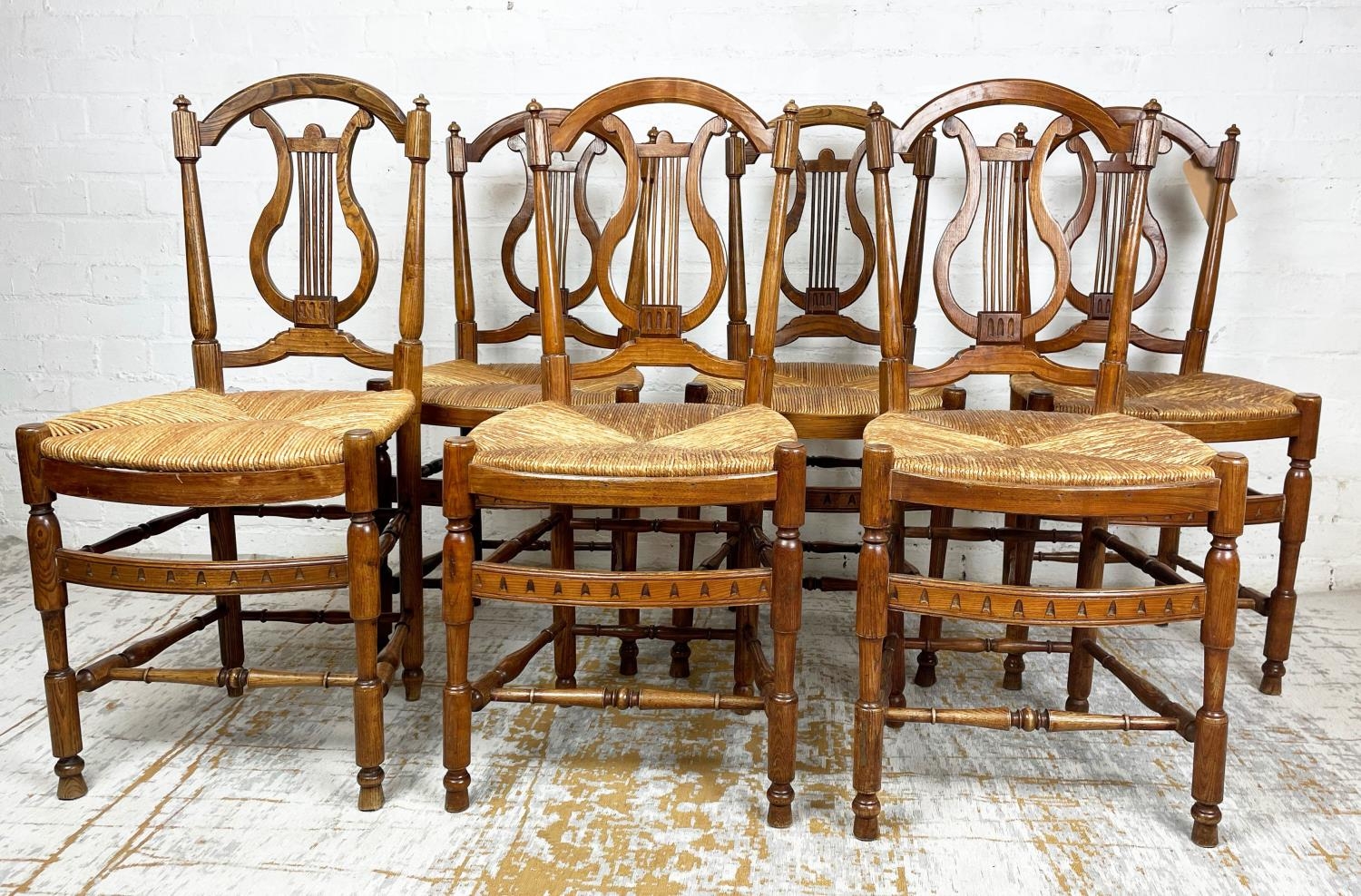 DINING CHAIRS, six, late 19th century French Provincial ash with lyre backs and rush seats. (6)