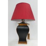 TABLE LAMP, black and gilt with red shade, 81cm H including shade.