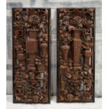 CHINESE CARVED WALL HANGINGS, a pair, with ornate foliate detail and various vases in black bordered