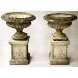 GARDEN URNS, a pair, weathered reconstituted sandstone campana urns on rosette centred plinths, 57cm