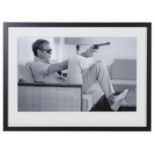 AFTER JOHN DOWNING, 'Steve Mcqueen with gun', 74cm x 54cm, framed and glazed.