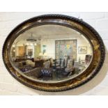 CHINOISERIE WALL MIRROR, early 20th century, lacquered frame with bevelled oval plate, 63cm H x