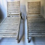 SUN LOUNGERS BY BARLOW TYRIE, a pair, weathered teak with rising back rest, drinks supports and