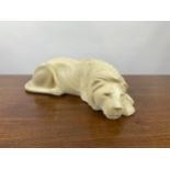 SLEEPING LION, carved sandstone. 45cm L