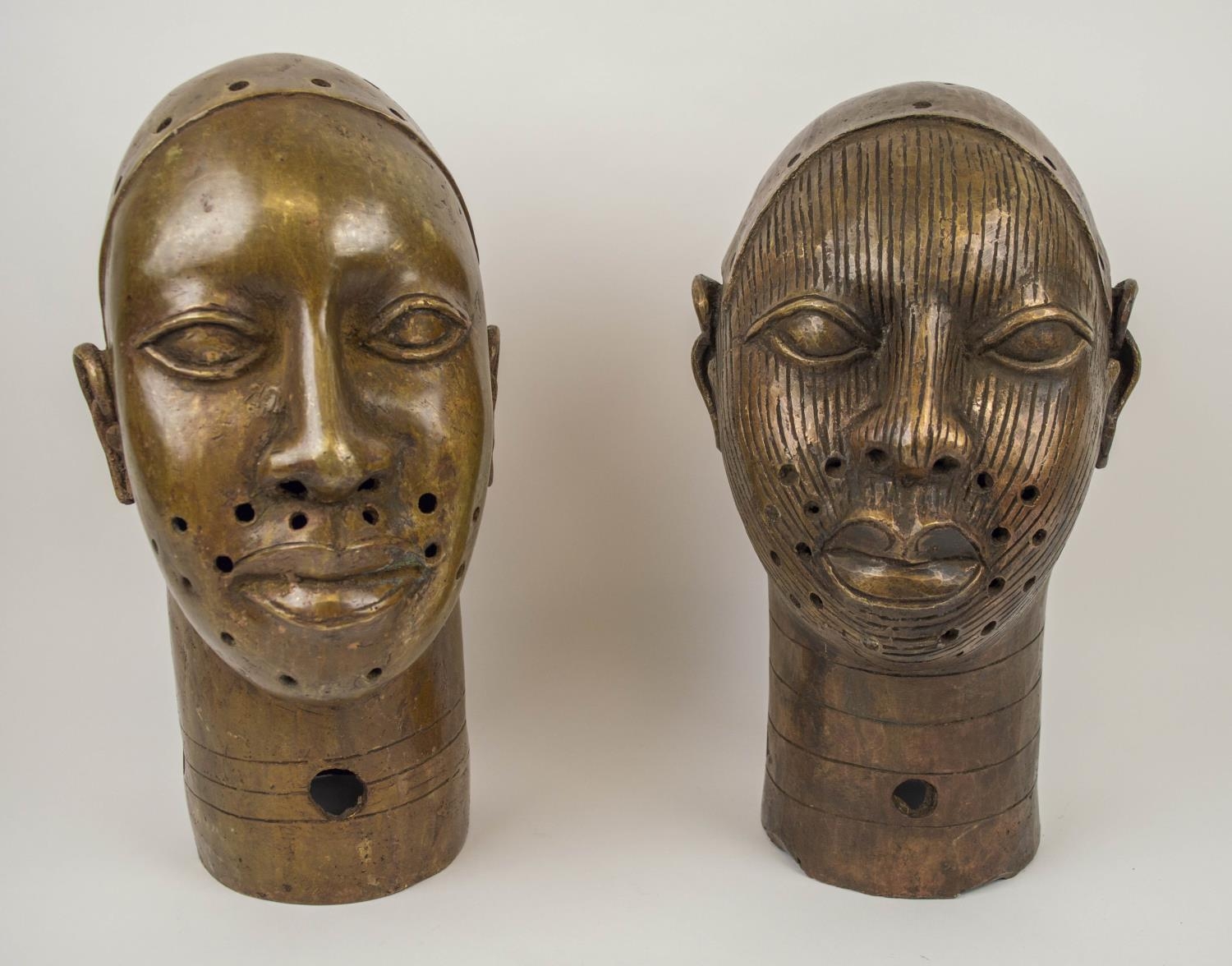 BRONZE BENIN KING OBA HEADS, a pair, of the Yoruba people of Nigeria, 34cm x 18cm. (2)