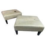 COWHIDE FOOTSTOOLS, a pair, with ebonised supports, 40cm H x 76cm x 62cm. (2)