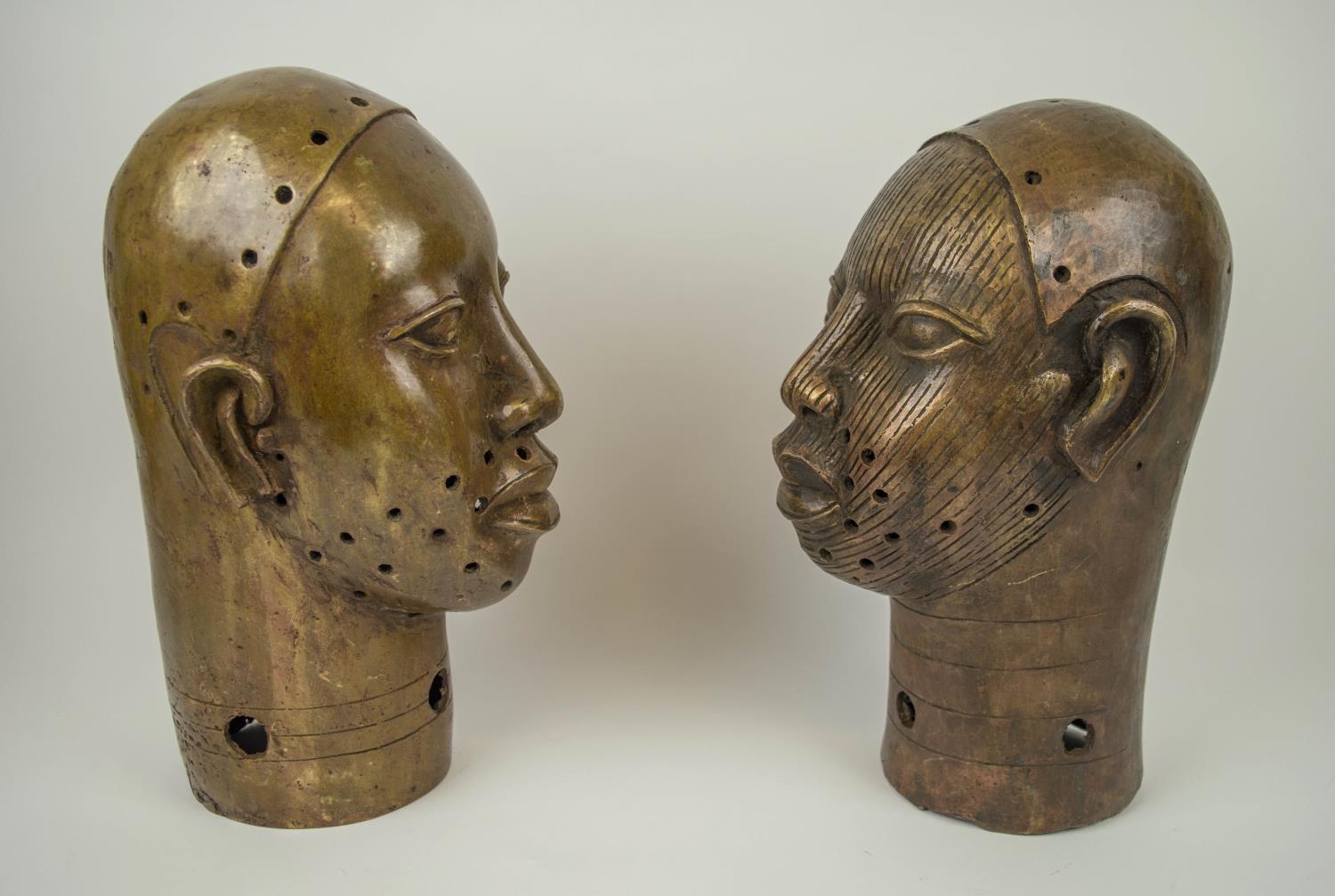 BRONZE BENIN KING OBA HEADS, a pair, of the Yoruba people of Nigeria, 34cm x 18cm. (2) - Image 3 of 5