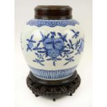 CHINESE GINGER JAR, 35cm H x 28cm, blue and white china with carved wooden top and wooden stand.