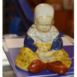 AN EARLY 20THC QUIMPER FIGURE OF A SEATED CHILD, DESIGNED BY BERTHE SAVIGNY, SIGNED PAINTED MARK