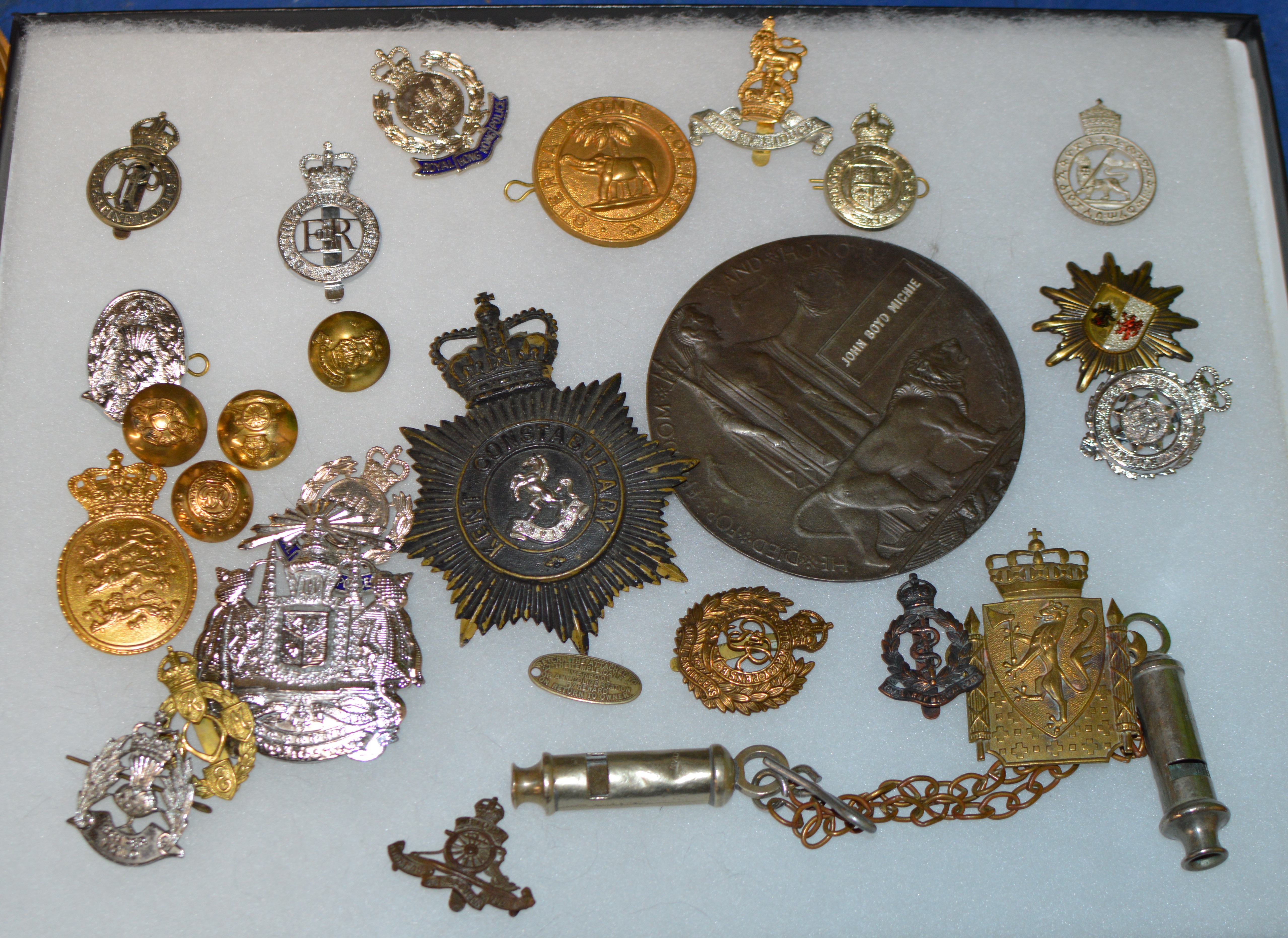 DISPLAY CASE WITH VARIOUS MILITARY STYLE BADGES, REPRODUCTION DEATH PLAQUE, WHISTLE ETC