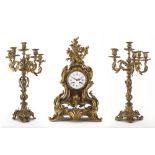 Trittico composto da una pendola da tavolo e due candelabri in bronzo dorato