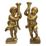 Coppia di putti porta cero in legno scolpito e dorato