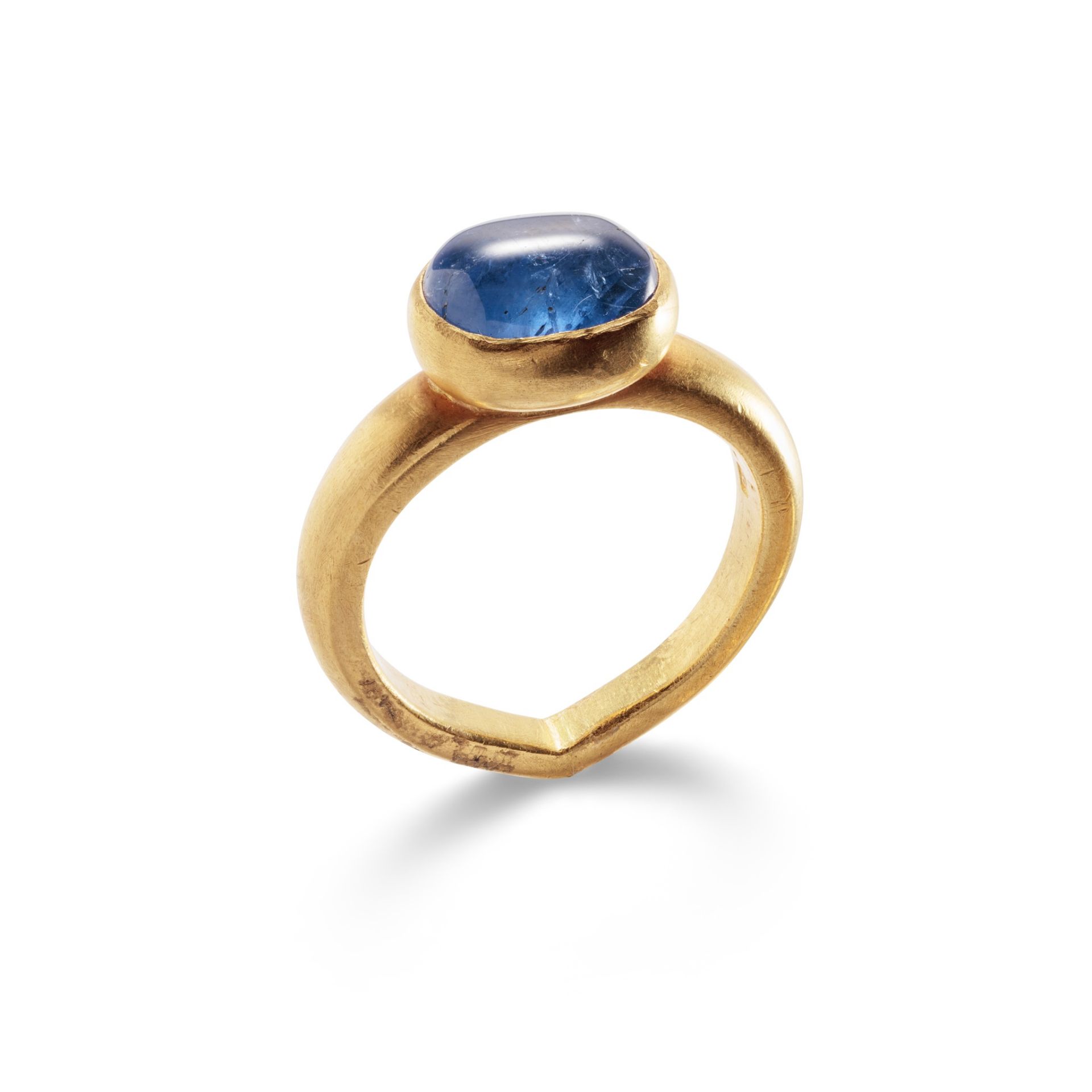 A sapphire single-stone ring The oval cabochon sapphire collet-set to an 18ct gold tapered hoop of