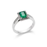 An emerald and diamond ring The cut-cornered rectangular-cut emerald to a brilliant-cut diamond