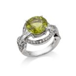 A peridot and diamond dress ring The circular-cut peridot within an openwork surround of brilliant-