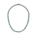 An emerald and diamond line necklace Composed of an alternating series of graduated brilliant-cut