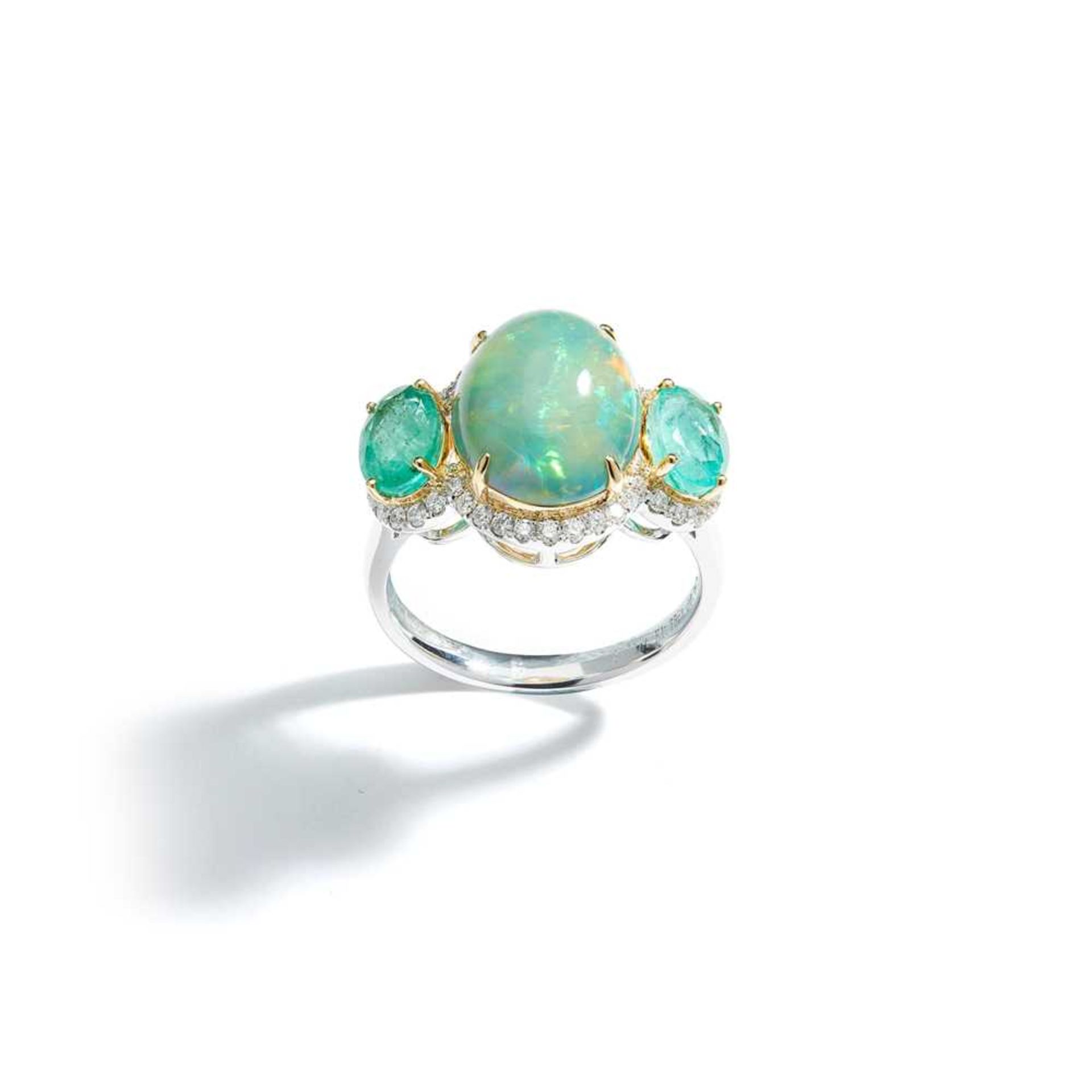 An opal, emerald and diamond three-stone ring