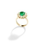 An emerald and diamond cluster ring