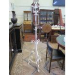 A painted wrought iron standard lamp, of scrolling form with tripod base, 158 cm high