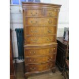 A reproduction crossbanded mahogany serpentine tallboy, with two short and three long graduated