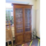 An oak and lead glazed bookcase cabinet, the moulded cornice over a pair of doors enclosing