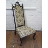 A Victorian rosewood nursing chair, the C-scroll top rail over an upholstered back and turned