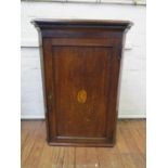 A George III oak hanging corner cabinet, the dentil cornice over a shell inlaid panelled door, 69 cm