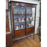 A 1930s mahogany display cabinet, the glazed doors with quarter veneered panels on square tapering