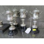 A set of four small silver trophy cups and covers on stand by Maplin & Webb