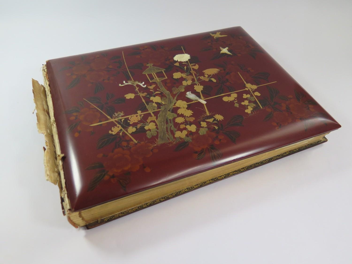 A Japanese red lacquered and mother of pearl inset photo album, containing fifty coloured
