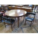 A 1960s rosewood extending circular dining table, by A.H. McIntosh, with integrated leaf and