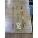 A set of three brass fire irons, with foliate designs, poker 65 cm long