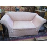 An upholstered box settee, the shaped back over a hinged seat and scroll arms, pink upholstery,