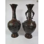 A pair of Japanese bronze vases, depicting cranes and birds in branches, one vase lacking twin